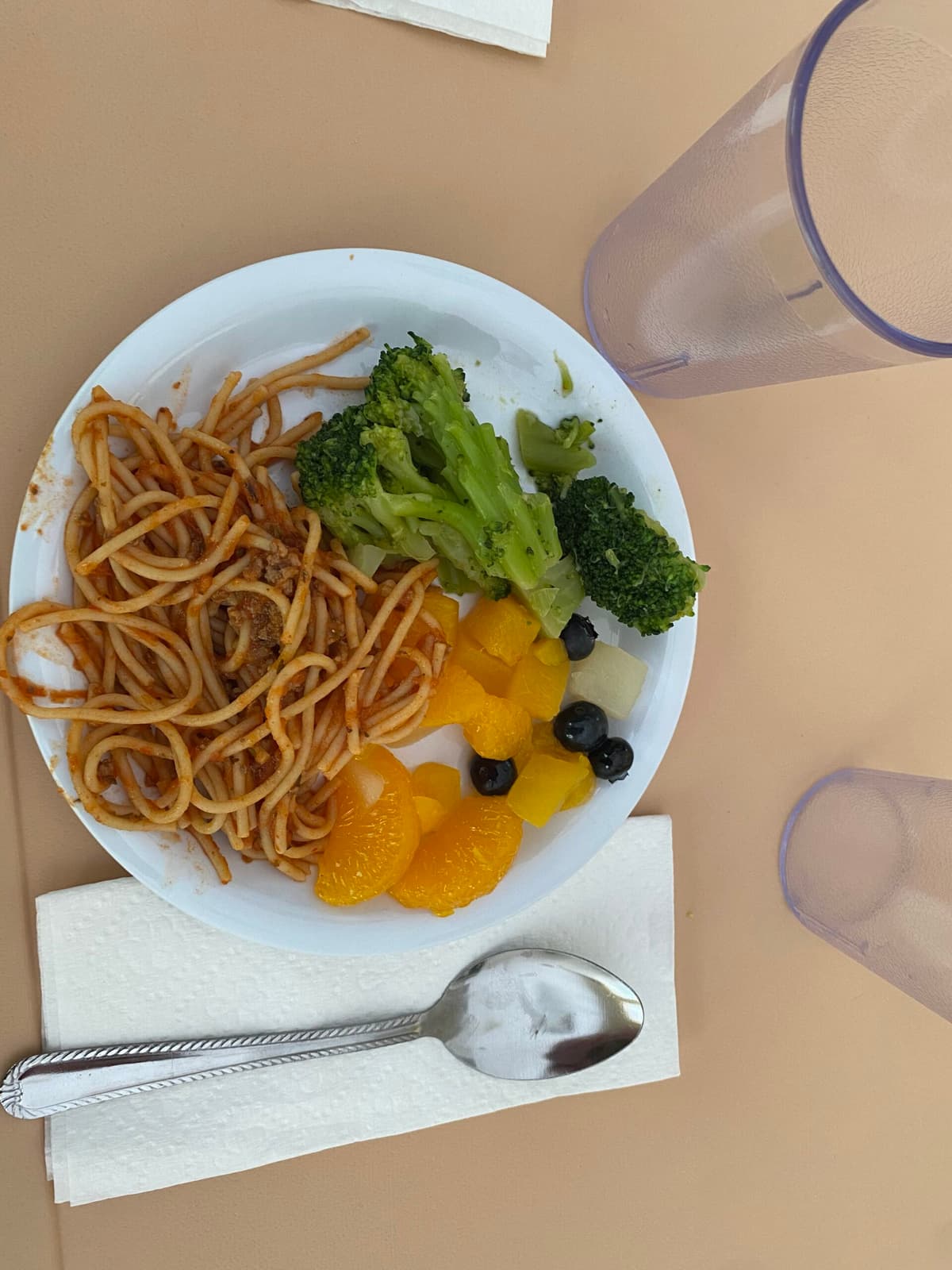 Nutritious meal with pasta, broccoli, and oranges served on child's plate