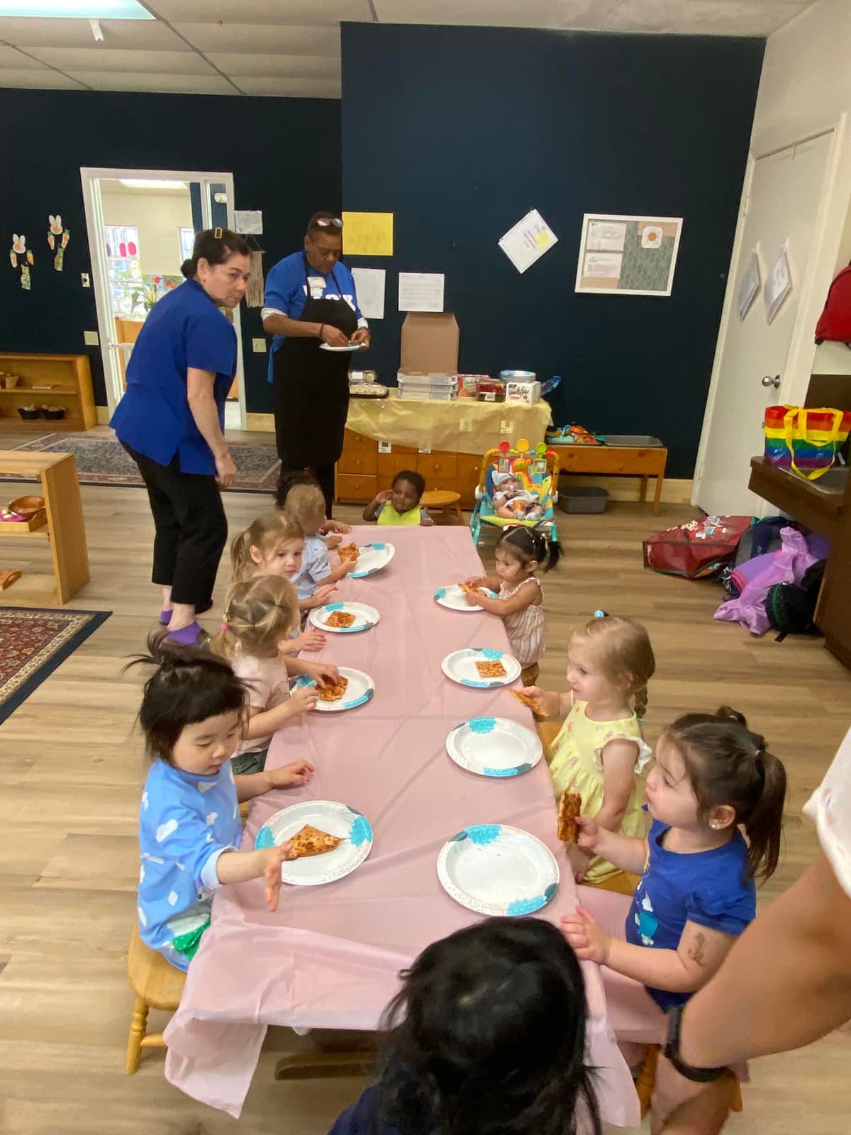 Children sitting around table enjoying family-style meal in dining area